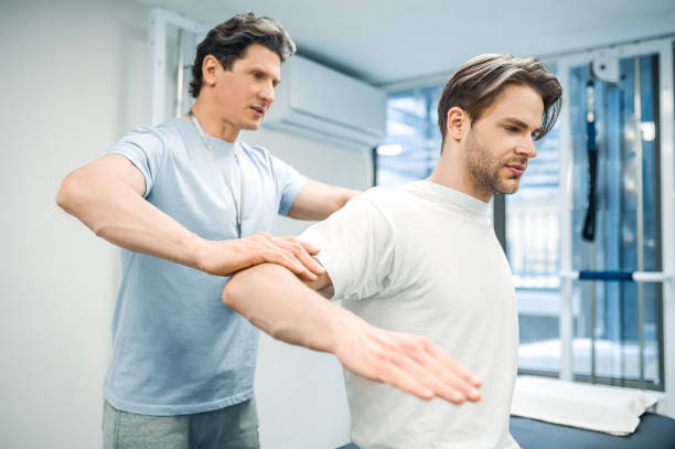 istock Male physical therapist working with a patient and looking invloved 1480590169