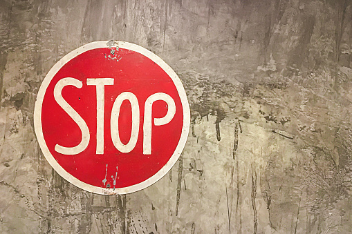 Vintage traffic sign Stop on concrete wall.
