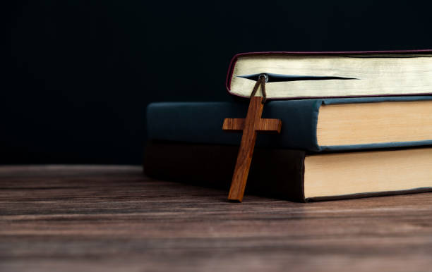 Bible and religious cross on wooden table