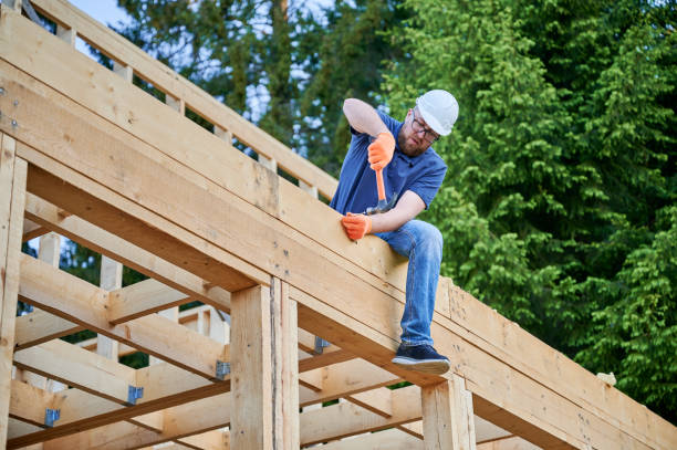 istock Carpenter hammering nail while constructing wooden frame two-story house near the forest. 1480592156
