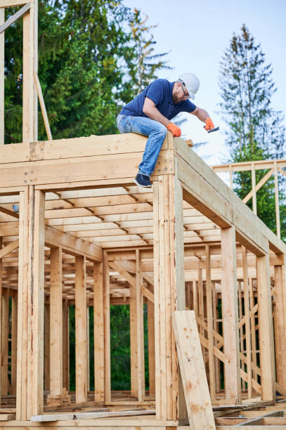 istock Carpenter hammering nail while constructing wooden frame two-story house near the forest. 1480592168