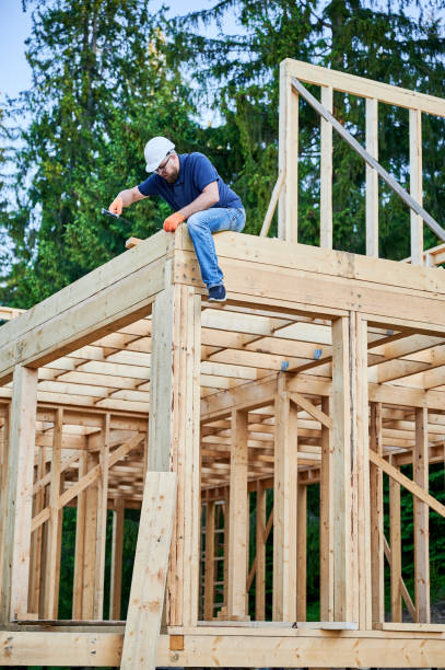 istock Carpenter hammering nail while constructing wooden frame two-story house near the forest. 1480592173
