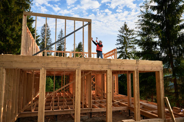 istock Carpenter hammering nail while constructing wooden frame two-story house near the forest. 1480592246