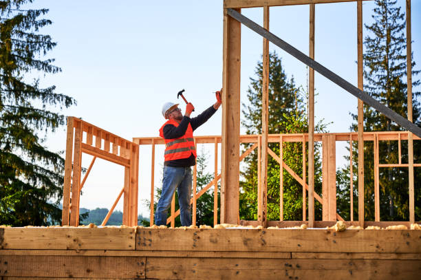 istock Carpenter hammering nail while constructing wooden frame two-story house near the forest. 1480592253
