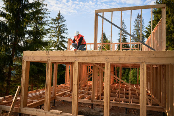 istock Carpenter hammering nail while constructing wooden frame two-story house near the forest. 1480592274