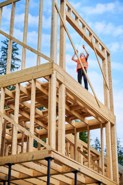 istock Carpenter measures distance with tape measure while building wooden frame house. 1480592343