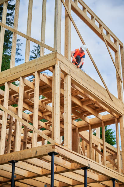 istock Carpenter hammering nail while constructing wooden frame two-story house. 1480592353