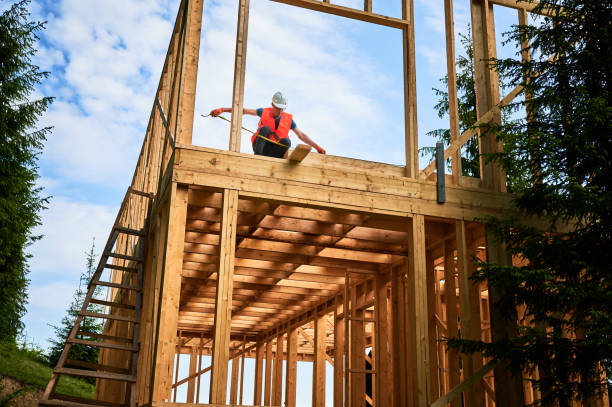 istock Carpenter measures distance with tape measure while building wooden frame house. 1480592354