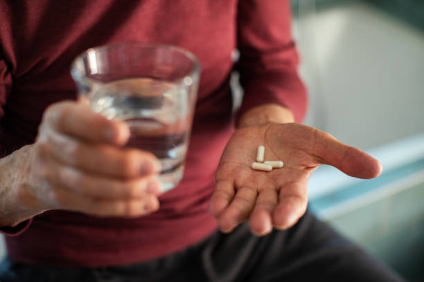 istock Senior man taking a pill in a bathroom 1480595432