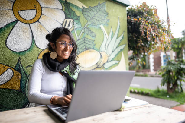 donna adulta di metà che utilizza un computer portatile alla caffetteria - outdoors business computer laptop foto e immagini stock