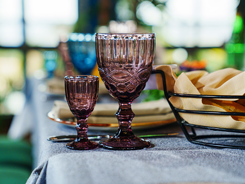 glasses of colored glass on a table with a blue tablecloth. beautiful dishes for home and restaurant.