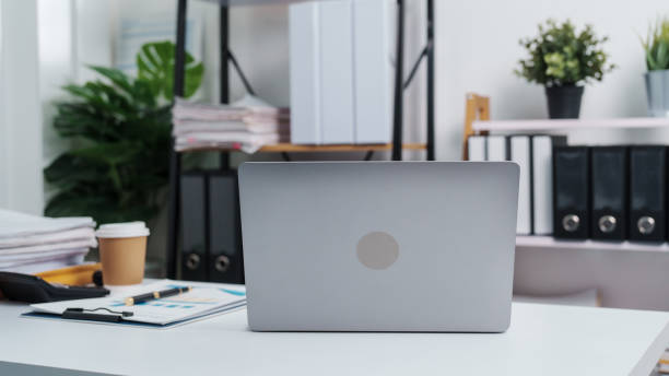 istock Stylish workspace with laptop, notebook, blank screen laptop on white table of bookkeeping. 1480598394