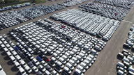 istock Large parking lot with new cars for sale Aerial view in port of large sea city arrived by cargo ship in country drone turn automotive plant 1480601367