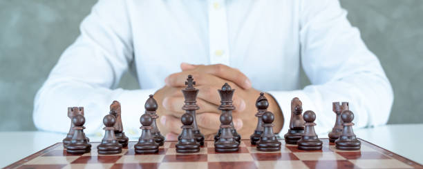 チェスの戦い、勝利、成功、リーダー、チームワーク、ビジネス戦略。ビジネスマンはビジネススーツを着て、キングチェスの駒を動かし、戦略を計画し、成功したビジネス競争のリーダー� - risk board game board game victory war ストックフォトと画像