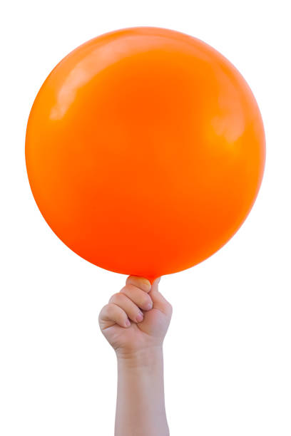 a criança está segurando um balão laranja. - balloon moving up child flying - fotografias e filmes do acervo
