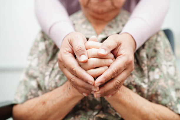 caregiver holding hands asian elderly woman patient, help and care in hospital. - ouderenzorg stockfoto's en -beelden