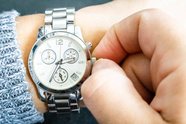 istock Wristwatch on a young white woman's arm being adjusted to indicate the correct time according to the arrival location after travel. Reference to time zone differences in different countries. 1480607666