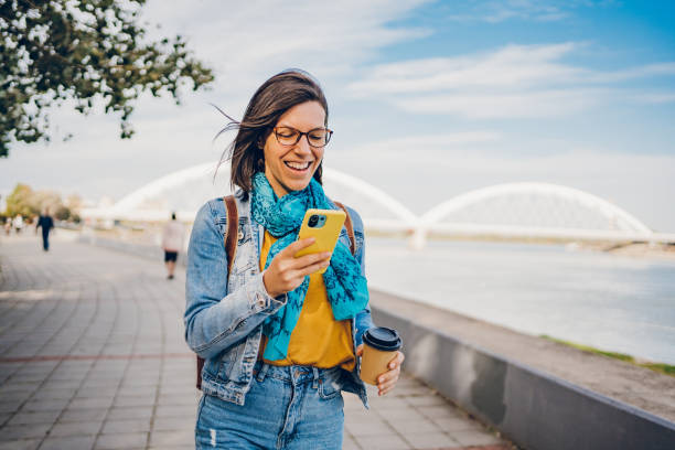 istock A woman walks around the city using a mobile phone 1480608188