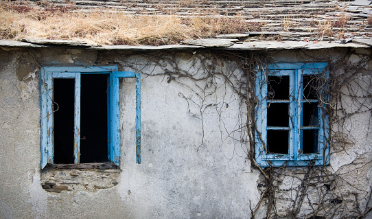 Blue windows, abandoned house facade. Lugo city, Galicia, Spain.