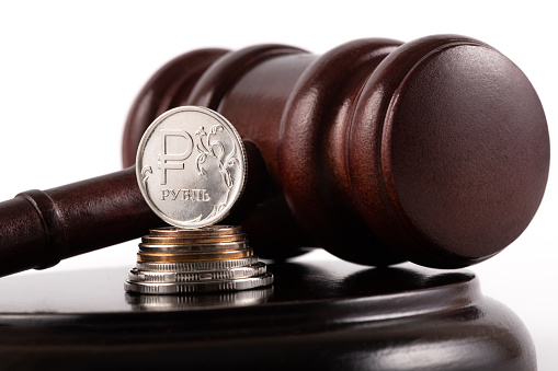 Judge gavel and coin with Russian ruble symbol on white background