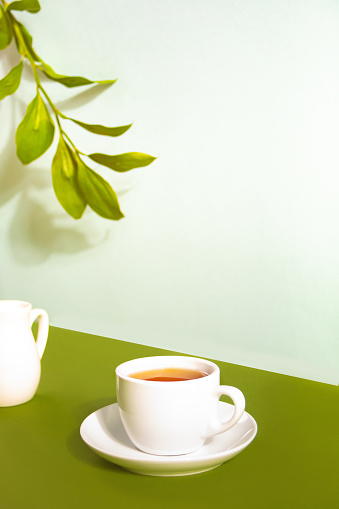 Mockup a cup of tea and tea leaf on the white desk. Free space for text