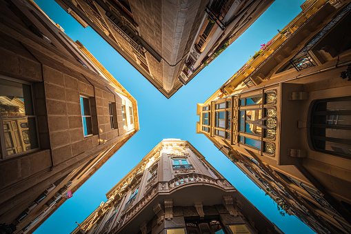 View from below of four buildings in the old town of Murcia with narrow streets and blue sky