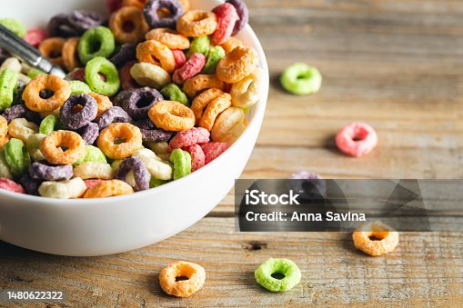 istock Colored breakfast cereals in a bowl on a wooden background, close up. 1480622322