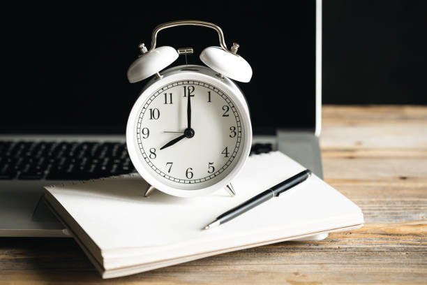 istock Alarm clock, notepad and laptop at the workplace, close-up. 1480622323