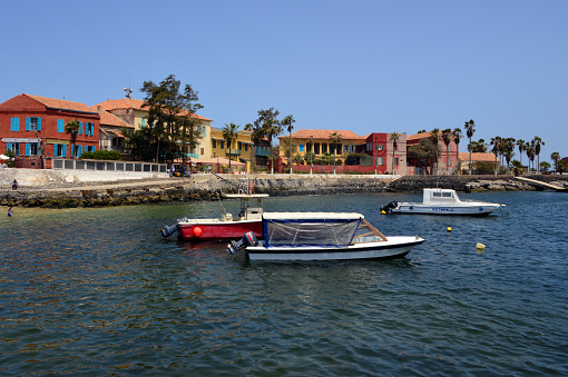 Island of Gorée, Dakar, Senegal: piers and colorful façades on the harbor waterfront, along Hesse street, the corniche - from the left the Chevalier de Boufflers building, the Maurel Frères building (1822) converted to a post office, the old residence of Prince Sadruddin Aga Khan (known as the 'Principality', approx. 1880) and the old palace of the American consul-general to French West Africa, Captain Peter Strickland (1884).