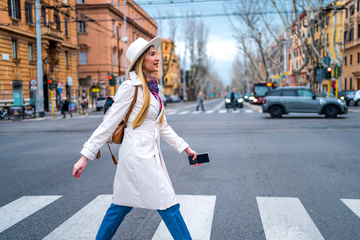 Young cheerful woman crossing the street in Rome, Italy