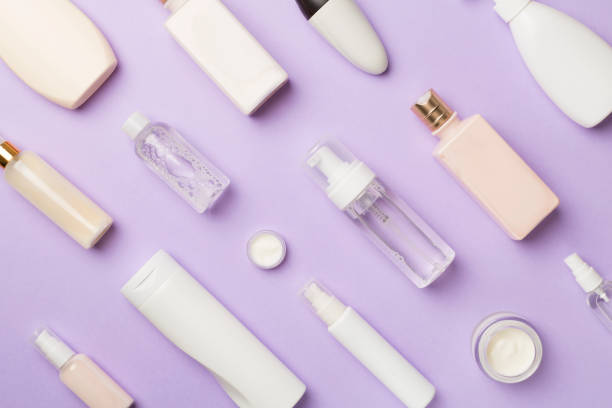 istock Different cosmetic bottles on color background, top view 1480626412