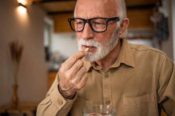 istock Photo of an elderly man at home taking regular medication. 1480626929