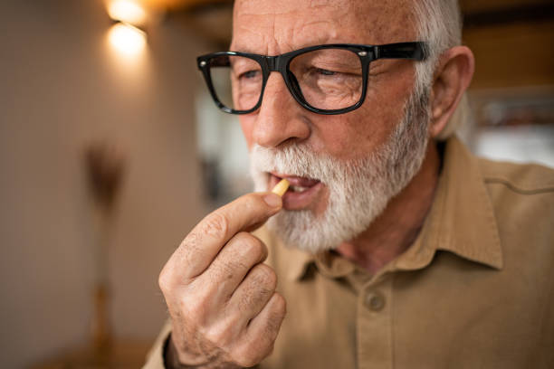 istock Photo of an elderly man at home taking regular medication. 1480626930