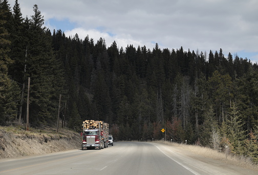 Hope-Princeton Highway, Canada - March 30, 2023: A logging truck heads west along the Hope-Princeton Highway segment of Crowsnest Highway or Highway 3. Spring afternoon in the Cascades in the Regional District of Okanagan-Similkameen in southern British Columbia.