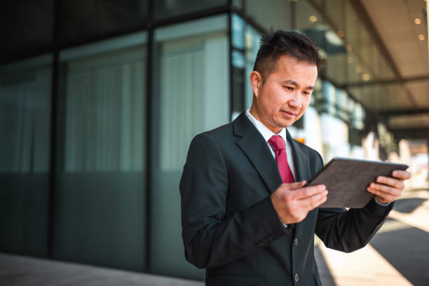 istock Chinese Businessman Using Digital Tablet Outdoors 1480635372