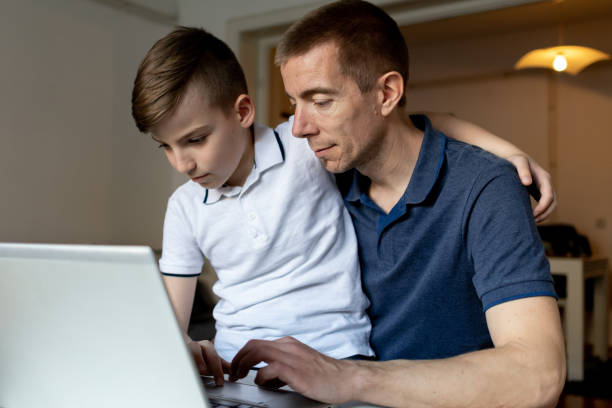 istock Father and son studying with laptop on a online class at home 1480637546