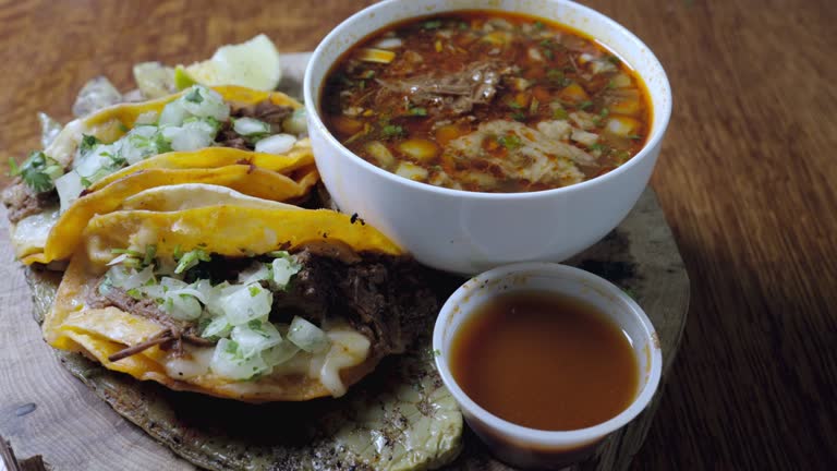 Warm soft corn tortillas filled with savory carne asada, topped with crumbled cheese, a squeeze of fresh lime, served on a rustic wood cutting board. Authentic street tacos