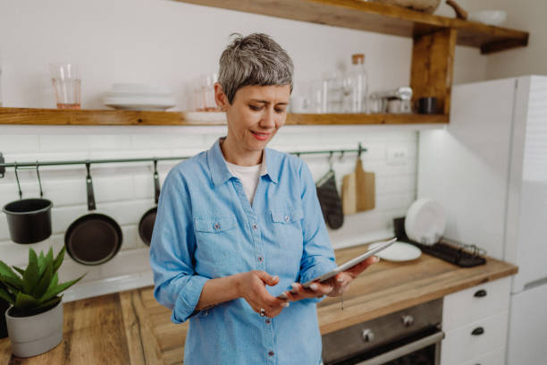 istock Senior woman standing and holding her digital tablet 1480641720