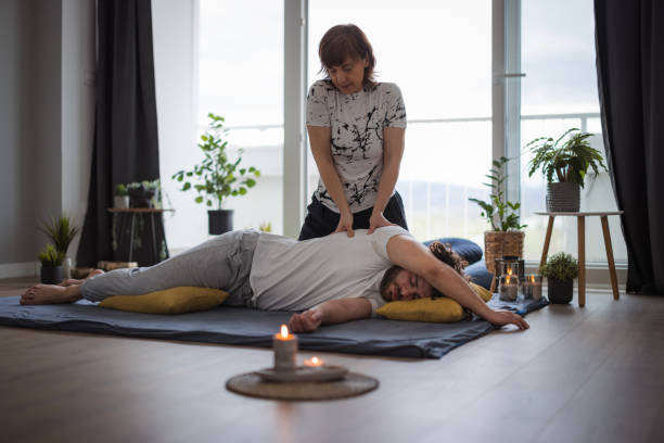 praticien de shiatsu appliquant une pression sur le torse latéral du patient - torso physical therapy patient relaxation exercise photos et images de collection