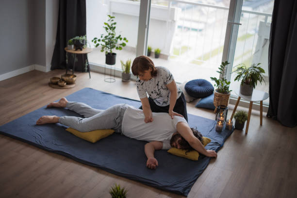 praticien de shiatsu appliquant une pression sur le torse latéral du patient - torso physical therapy patient relaxation exercise photos et images de collection