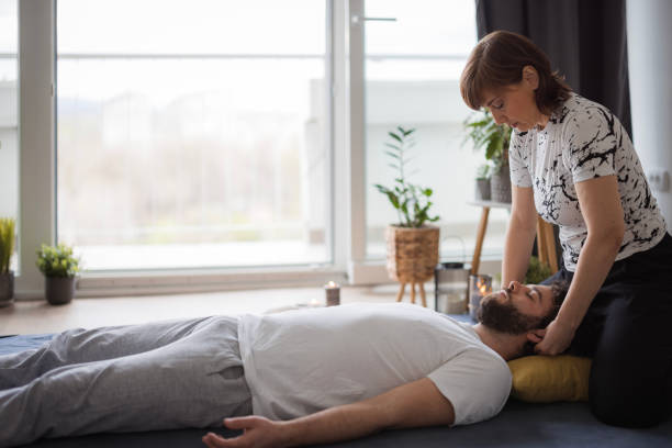 Shiatsu masseuse applying pressure on patient's ears