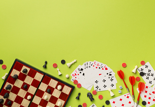 Different board games on color background, top view.