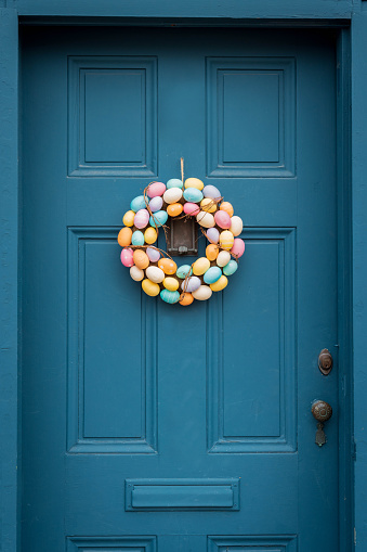 A wreath of Easter eggs hangs on a classic New England door