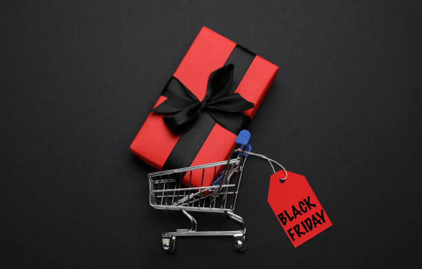 istock Shopping cart, tag with phrase BLACK FRIDAY and gift box on dark background, flat lay 1480657516