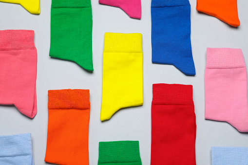 Different colorful socks on grey background, flat lay