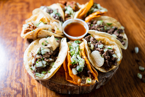 Delicious street tacos filled with birria, carne asada, onion, and cilantro, topped with flavorful salsa, served on a warm corn tortilla for the ultimate Mexican food experience
