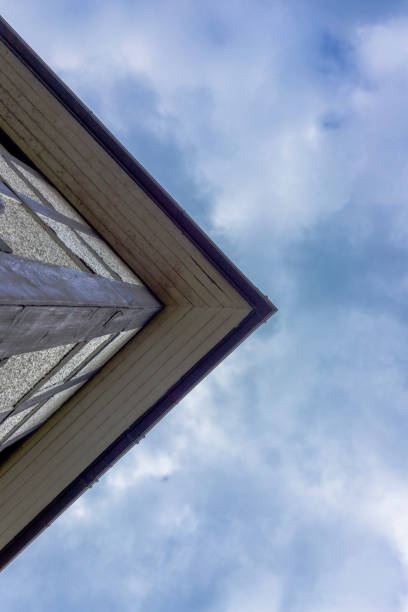 The top of a modern building in Newcastle upon Tyne, England with blue sky and clouds above it. The building is pointed.