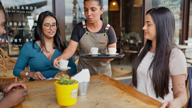 istock Waitress bring customers their order outside at a sidewalk cafe table 1480662286