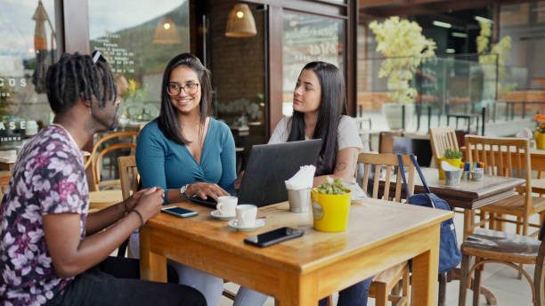 istock Smiling friends working on a laptop over cafe at a cafe 1480662294
