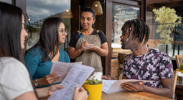 istock Friends giving a server their order while sitting at a cafe table outside 1480662327